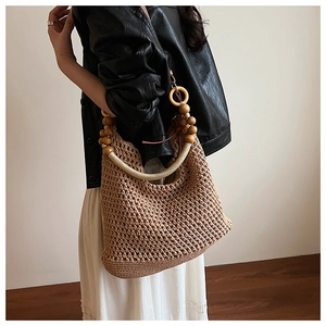 Close-up of bohemian knit tote bag with decorative yellow wooden bead handles