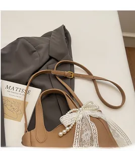 Detail of adjustable thin leather strap and gold buckle on a brown lychee pattern bucket bag