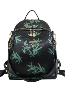 Black backpack with green bamboo leaf prints, featuring gold zippers and a top handle