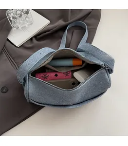 Internal view of the blue denim shoulder bag showing spacious storage for daily items