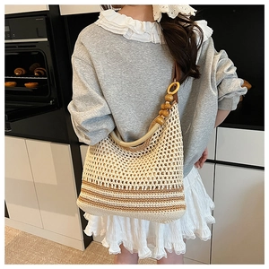Détail d'un sac à bandoulière tissé à la main avec base rayée et sangle en perles de bois