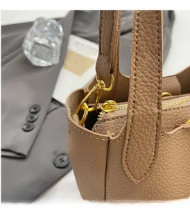 Close-up of brown lychee grain leather bucket bag with premium gold metal hardware detail
