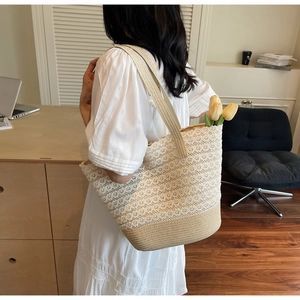Dettaglio della borsa tote intrecciata crema con ricami in pizzo e tracolla larga