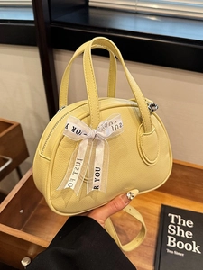 Chic yellow lychee pattern handbag with a decorative bow and detachable strap