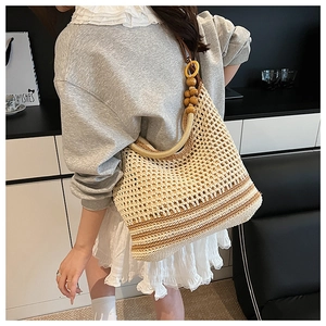 Détail du sac seau tissé main avec bandoulière en perles de bois pour la plage