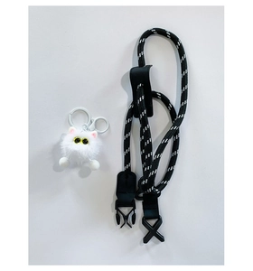 Detail of black and white woven lanyard with a soft white plush cat charm and metal clip