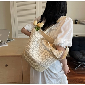 Dettaglio borsa shopper in pizzo beige con texture intrecciata e tulipani bianchi