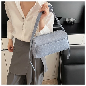 Detailed close-up of light blue denim crossbody bag featuring sleek rectangular design