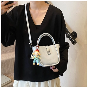 Detail of light blue bucket bag with silver metal lock and cute pearl charm accessory