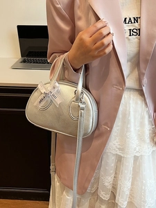 Silver textured shell-shaped crossbody bag with decorative ribbon and leather strap