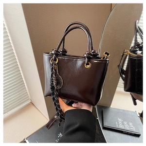 Détails du sac à main marron foncé brillant avec garnitures dorées et poignée nouée