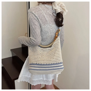 Détail du sac seau en maille Boho avec rayures bleues et bandoulière en perles de bois
