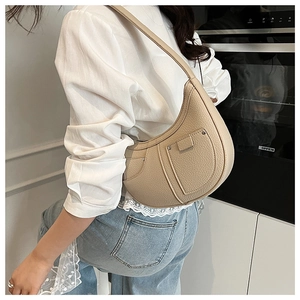 Detail of light beige hobo bag showing litchi grain leather and rivet pocket design