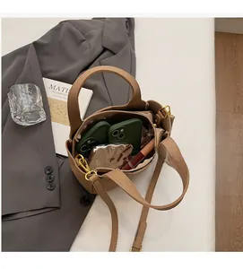 Internal view of brown pebble leather bucket bag showing capacity for phone and makeup