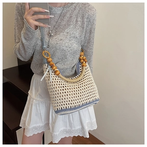 Détail du sac seau bohème en tricot avec poignée en perles de bois et rayures colorées