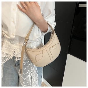 Detail of adjustable metal buckle and lychee leather texture on the apricot hobo bag