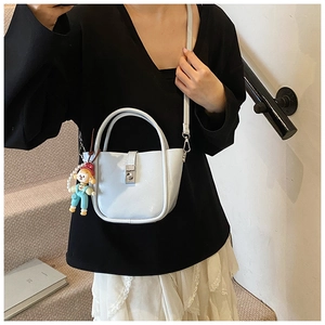 Detail of light blue bucket bag featuring a pearl charm and secure metal clasp closure