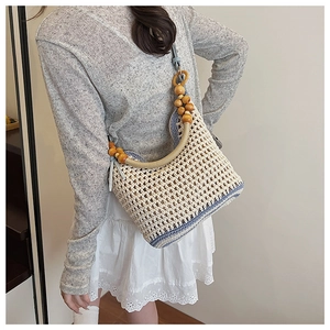 Gros plan détaillé du sac à bandoulière en maille crochet avec bordure bleue et perles