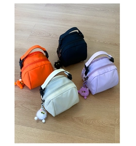 Group view of four lightweight nylon shell bags in orange, black, white and purple with cat charms