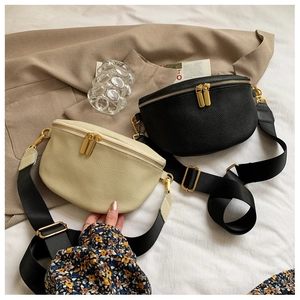 Detail of lychee textured leather waist bags with gold zippers and wide fabric straps