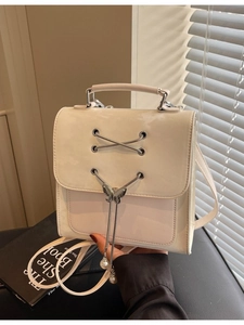Sac à dos chic en cuir verni beige avec papillon en métal et pendentif en perles