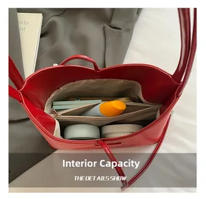 Vue de dessus de l'intérieur du sac seau en cuir rouge avec compartiments et objets
