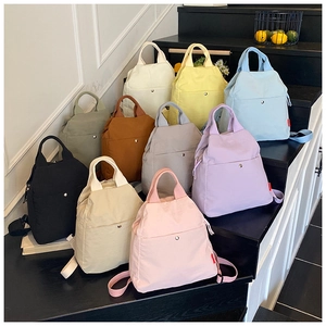 Detailed view of ten colorful multi-functional nylon chest bags arranged on indoor stairs