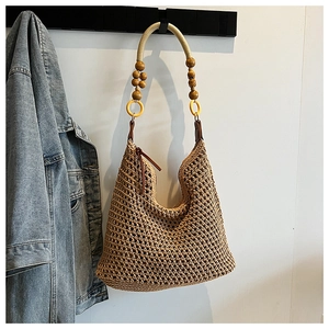 Détail du sac hobo en crochet bohème avec perles en bois et anneau jaune décoratif