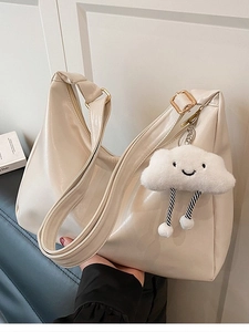 Creamy white Hobo tote bag with golden buckle and cute cloud charm in hand