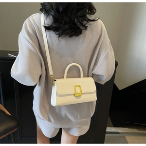 Détail du sac bandoulière blanc crème avec fermoir doré élégant et fine bandoulière