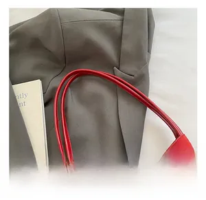 Détails de la couture sur la poignée d'un sac à bandoulière en cuir rouge élégant