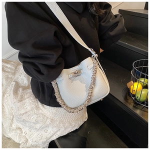 Dettaglio borsa a secchiello in pelle celeste motivo litchi con chiusura argento e catena