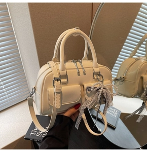 Detail of cream white mini Boston bag with pearl lace bow and silver dual zippers