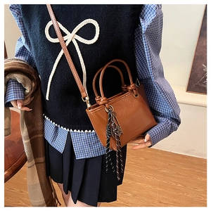 Mini sac seau rétro marron avec poignée texturée et ornement métallique rond