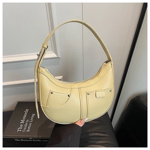 Detailansicht der hellgelben Sichel-Tasche mit Litschitextur und Metallnieten