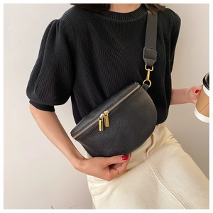 Detail of black crescent crossbody bag with lychee texture and gold double zippers