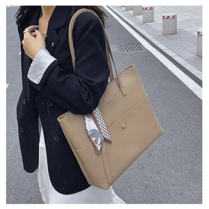 Detail of khaki tote bag featuring lychee texture leather and stylish patterned scarf