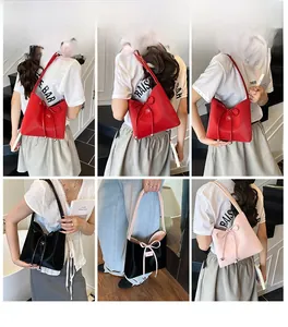 Détail de sacs à bandoulière brillants avec nœuds décoratifs et charms métalliques multicolores
