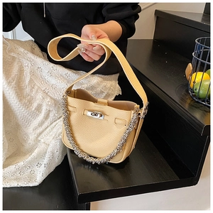 Dettaglio borsa a secchiello in pelle gialla con decorazione catena in metallo argento