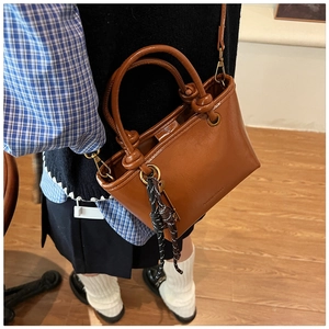 Détail du sac seau vintage marron avec poignées circulaires et lettrage SOPHIEMUI embossé
