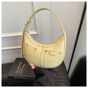 Detail of yellow pebbled leather hobo bag with silver rivets and utility pockets