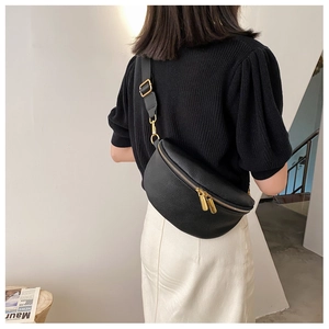Detail of black pebbled leather crossbody bag with adjustable strap on model back