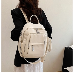 Detail of cream backpack with pebble texture and geometric woven shoulder strap