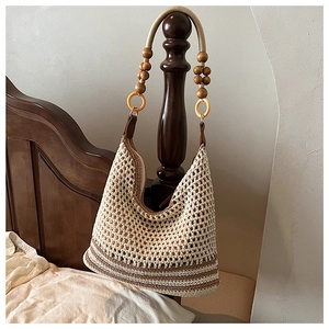 Détail du sac hobo en tricot avec rayures contrastées et bandoulière en perles de bois