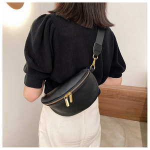 Close-up of black lychee grain leather waist bag with premium gold zipper details