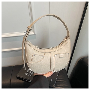 Detail der beigen Hobo-Tasche aus Leder mit dekorativen Taschen und silbernen Metallnieten