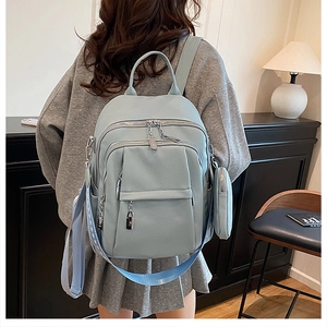 Detail of blue pebbled leather backpack with silver hardware and mini coin purse