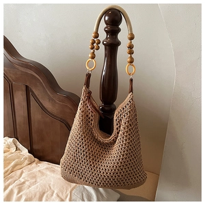 Détail du sac hobo en maille ajourée avec perles en bois et anneaux en résine décoratifs