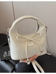 Sac bandoulière beige minimaliste avec nœud décoratif et bandoulière chaîne argentée