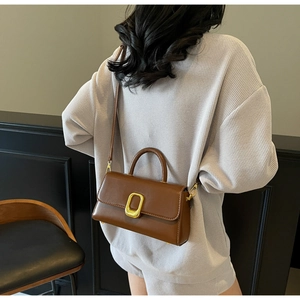 Sac bandoulière en cuir marron avec boucle dorée présenté dans une vue de dos chic